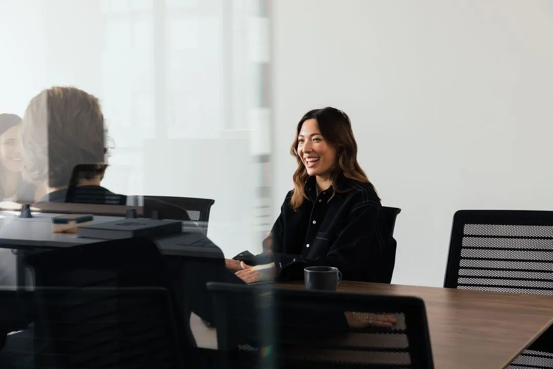 Colleagues sharing a conversation around a meeting table.